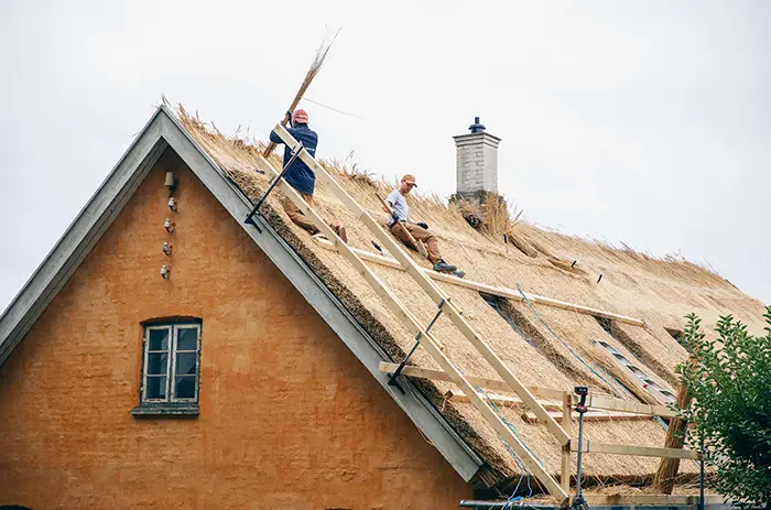 billede af tækkermænd der arbejder på et tag